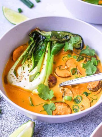 closeup of thai red curry soup and roasted bok choy