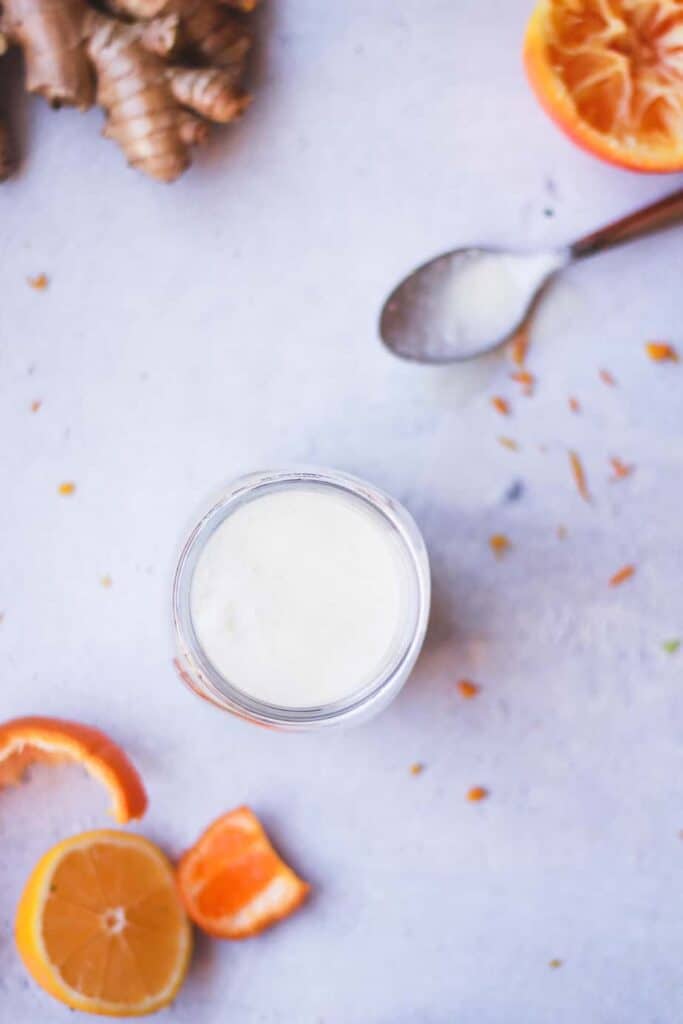 overhead shot of citrus ginger dressing with oranges and a spoon
