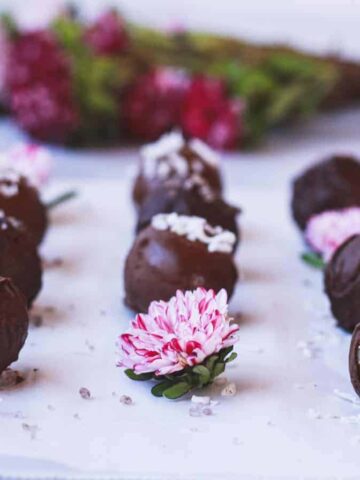 keto marzipan truffles with flowers in the background