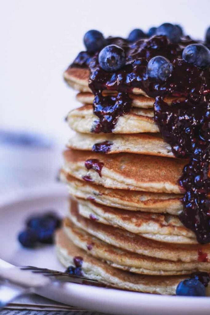stack of keto almond flour pancakes topped with blackberry sauce