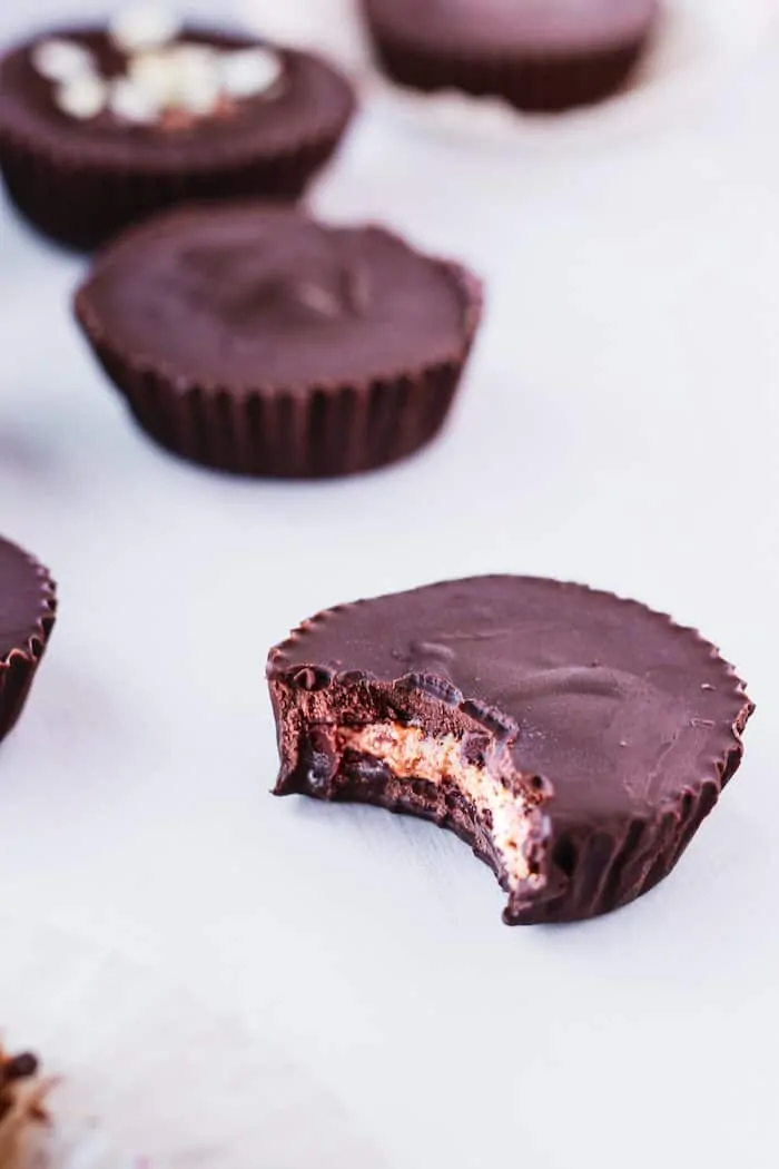 dark chocolate almond butter cup with a bite taken out of it