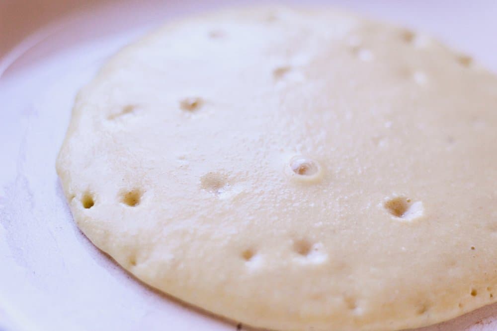 closeup of almond flour pancakes cooking in a pan