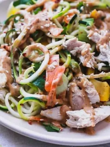 zucchini noodle salad with spicy peanut sauce on a plate