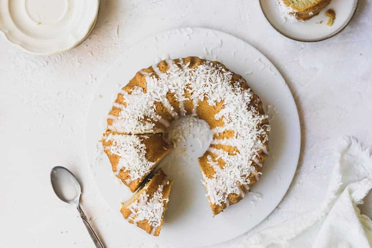 keto coconut cake on a platter with plates and napkin