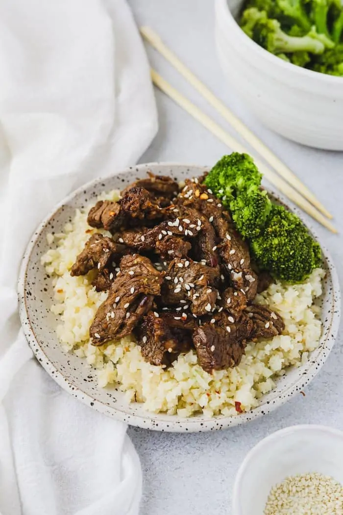 Low-carb beef bulgogi on a plate with cauliflower rice and broccoli