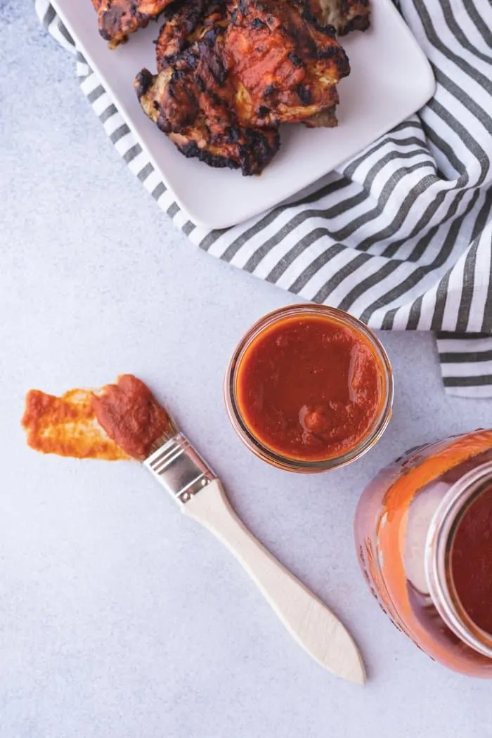 overhead of keto bbq sauce with chicken and two jars