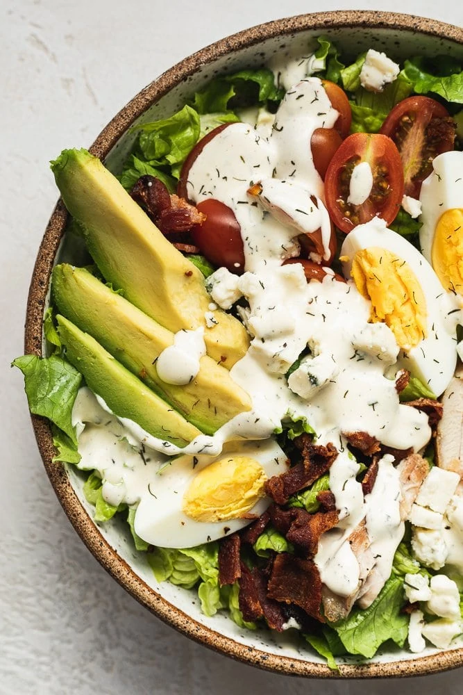 closeup of avocado and keto Cobb salad ingredients with dressing
