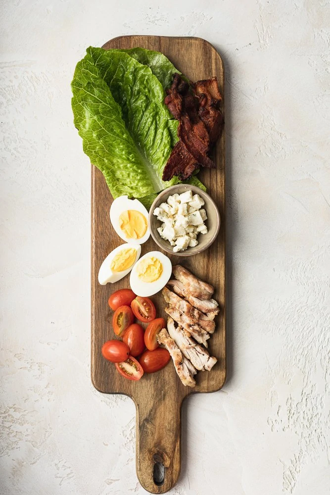 keto Cobb salad ingredients on a wood board