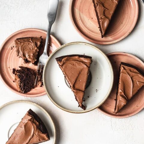 overhead of five plates with slices of keto chocolate cake