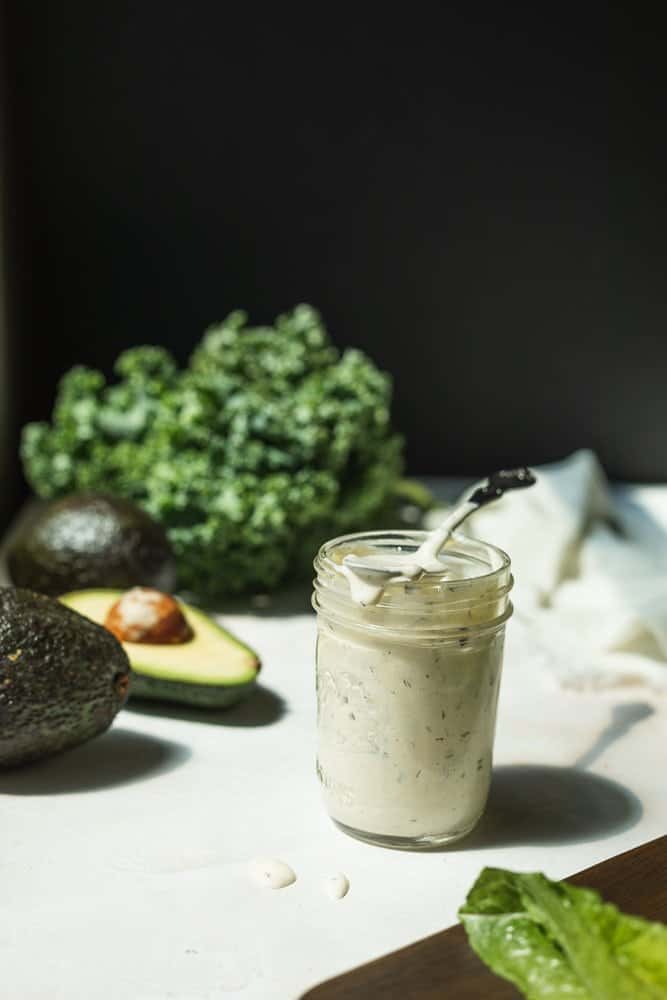 A mason jar with keto ranch dressing and a spoon.