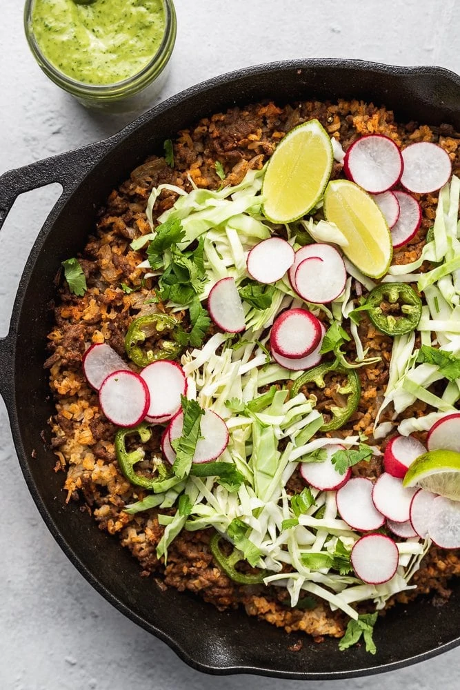 Overhead of keto taco casserole recipe with fresh vegetable toppings