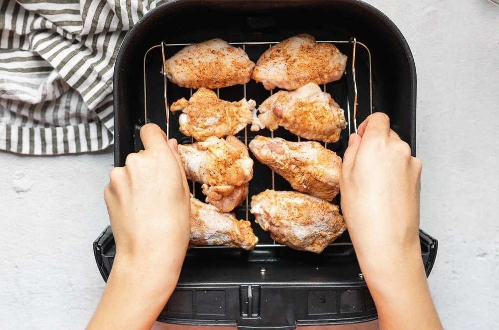 chicken wings on a rack placed into air fryer basket