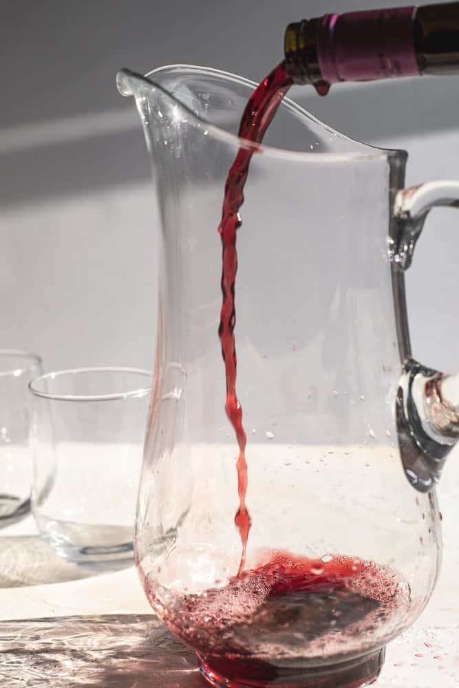 pouring pinot noir into a pitcher