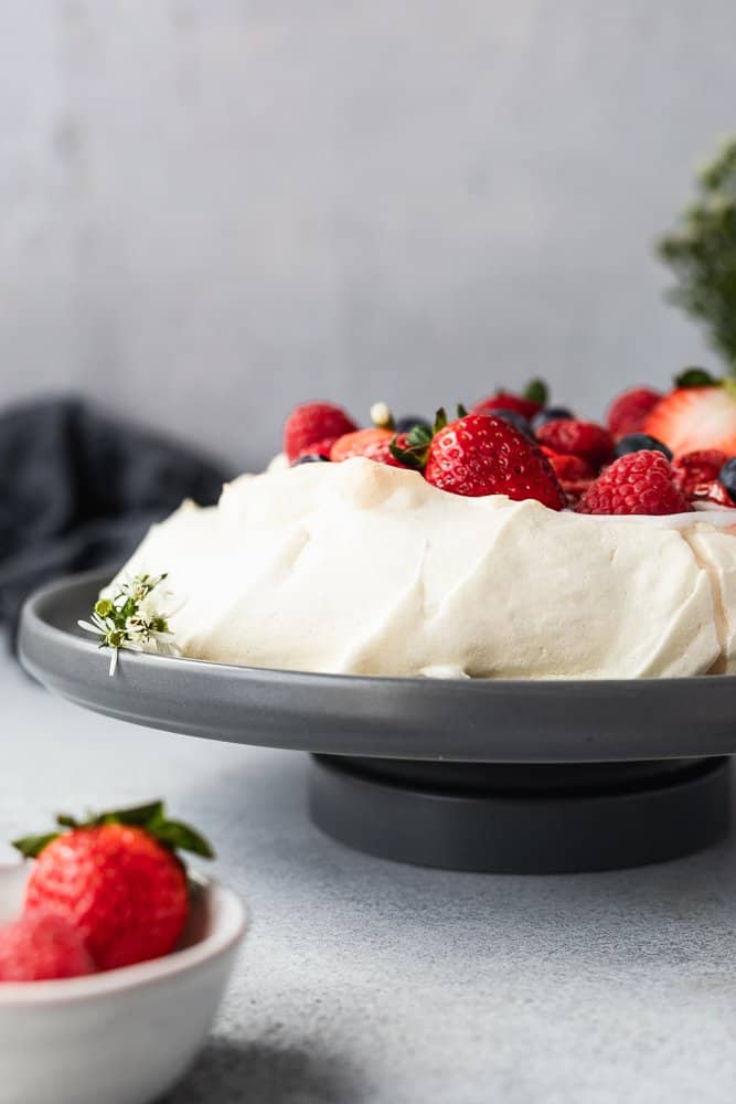 closeup of keto pavlova with florals and berries