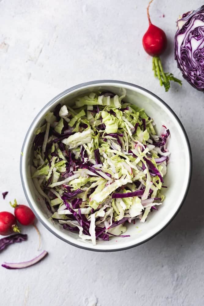 shredded cabbage and radish in a bowl for keto coleslaw
