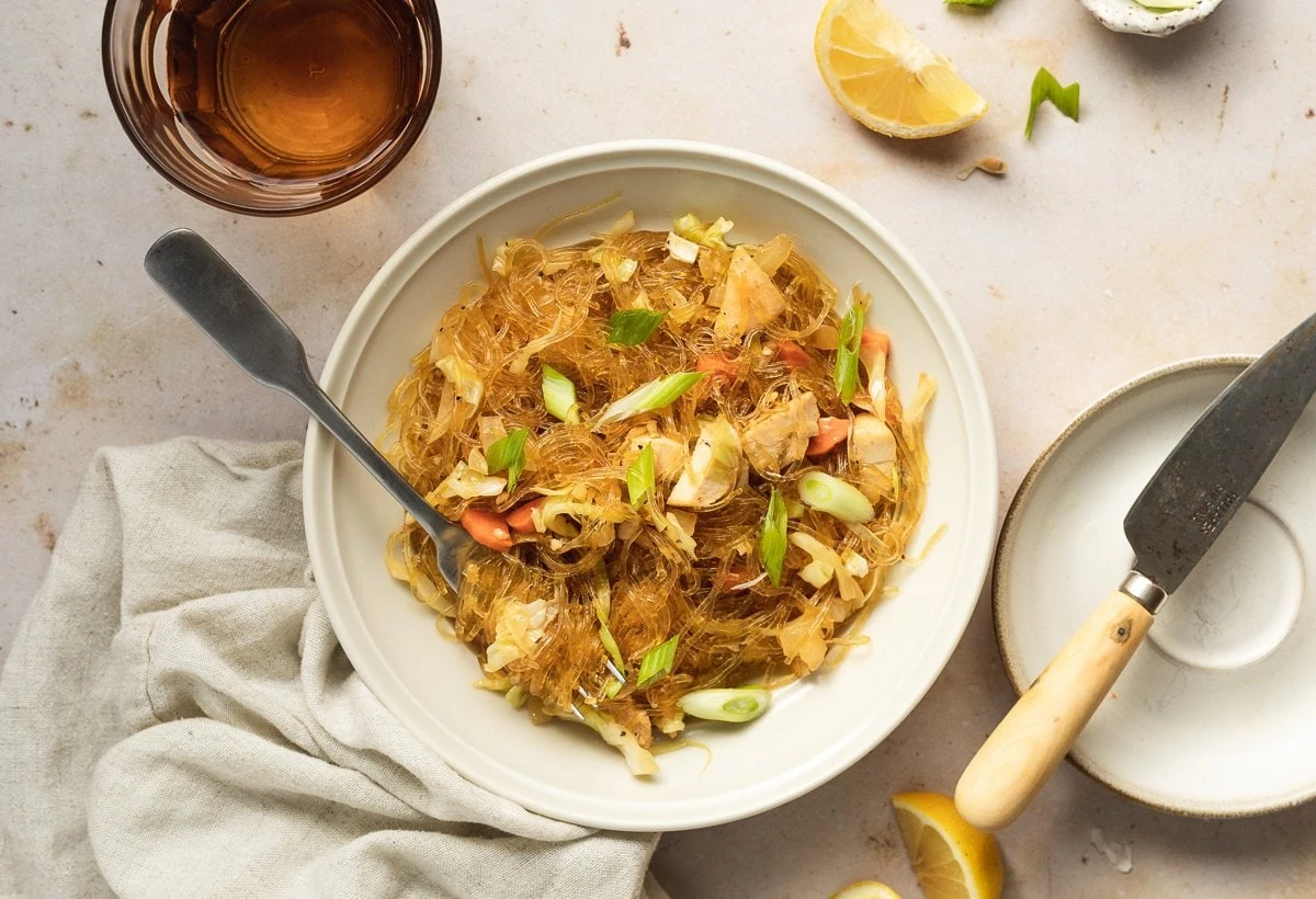 pancit with kelp noodles in a bowl with a glass and knife for Filipino pancit recipe