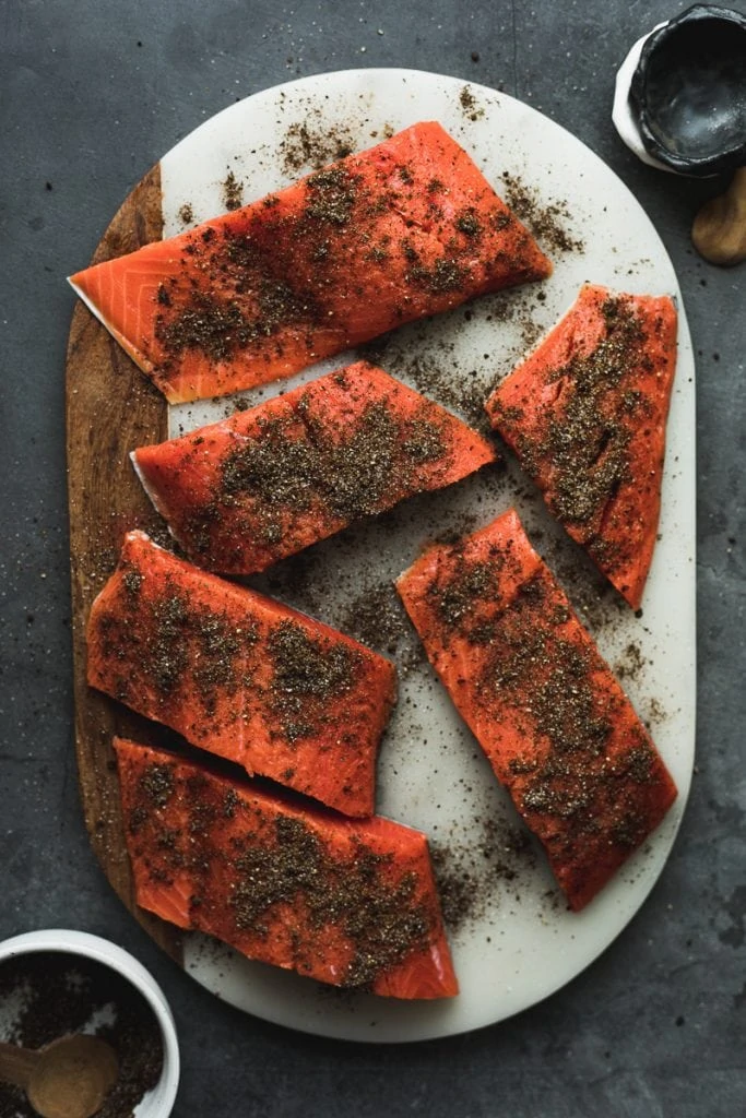 salmon on cutting board with coffee rub sprinkled on top