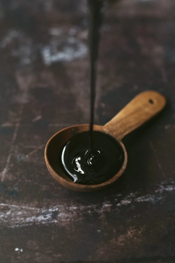 molasses being poured into a tablespoon