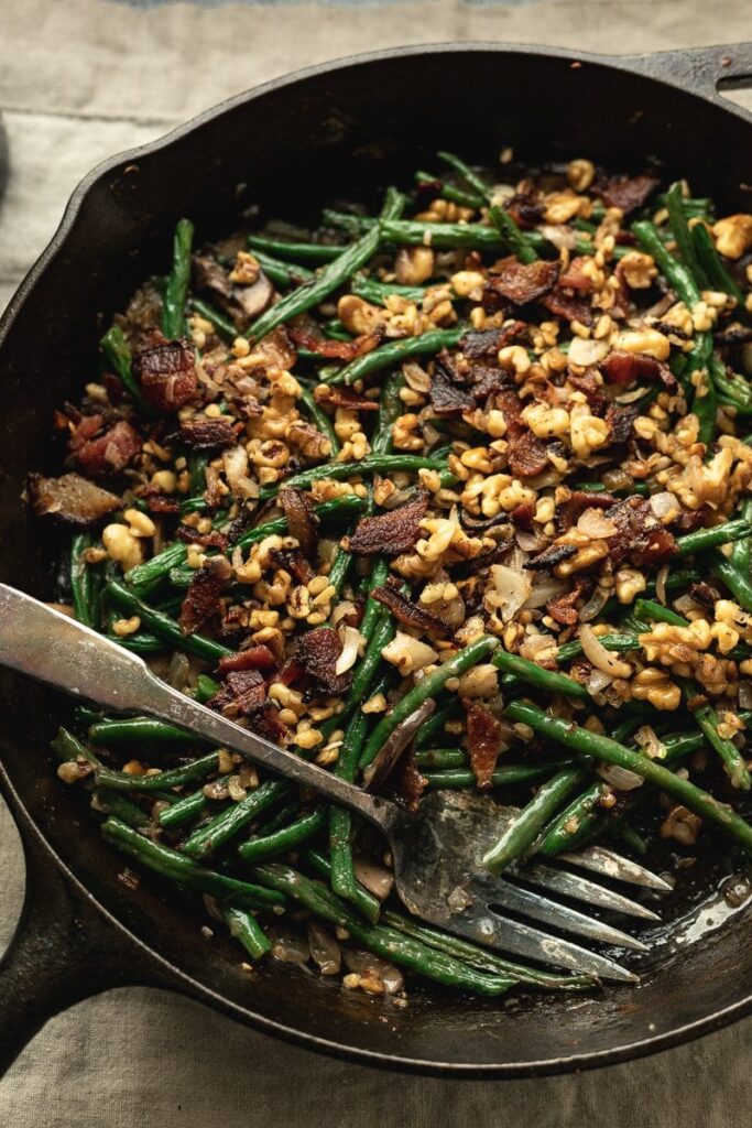 keto green bean casserole in a cast iron skillet with a serving fork
