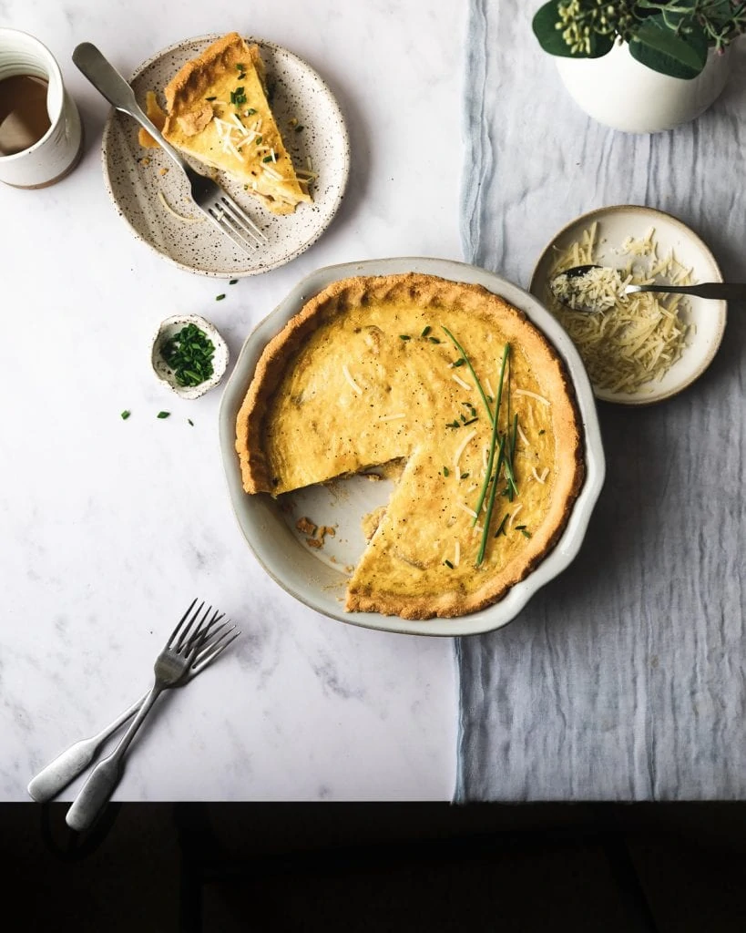 flatlay of keto quiche lorraine with silverware and slice cut out