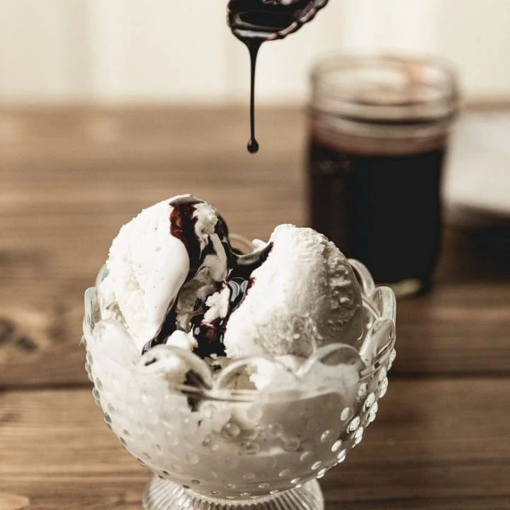 drizzling keto chocolate syrup on sugar-free ice cream