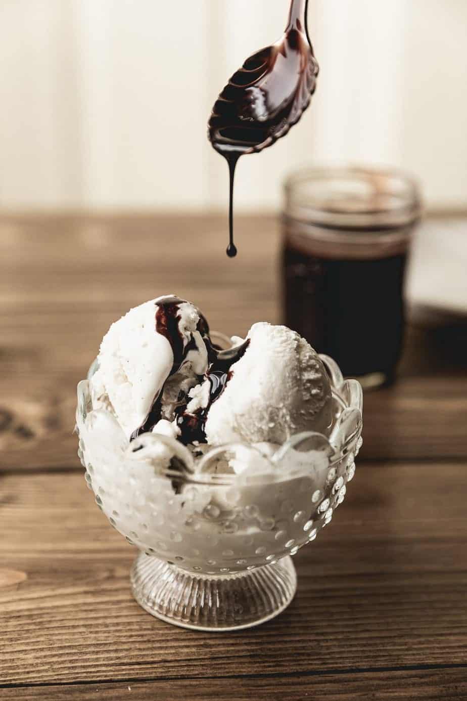 drizzling keto chocolate syrup on sugar-free ice cream