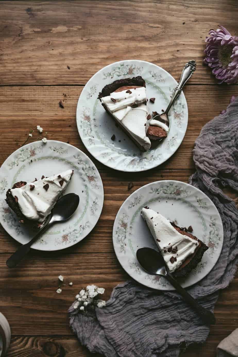 Slices of keto French silk pie on a wooden table. 
