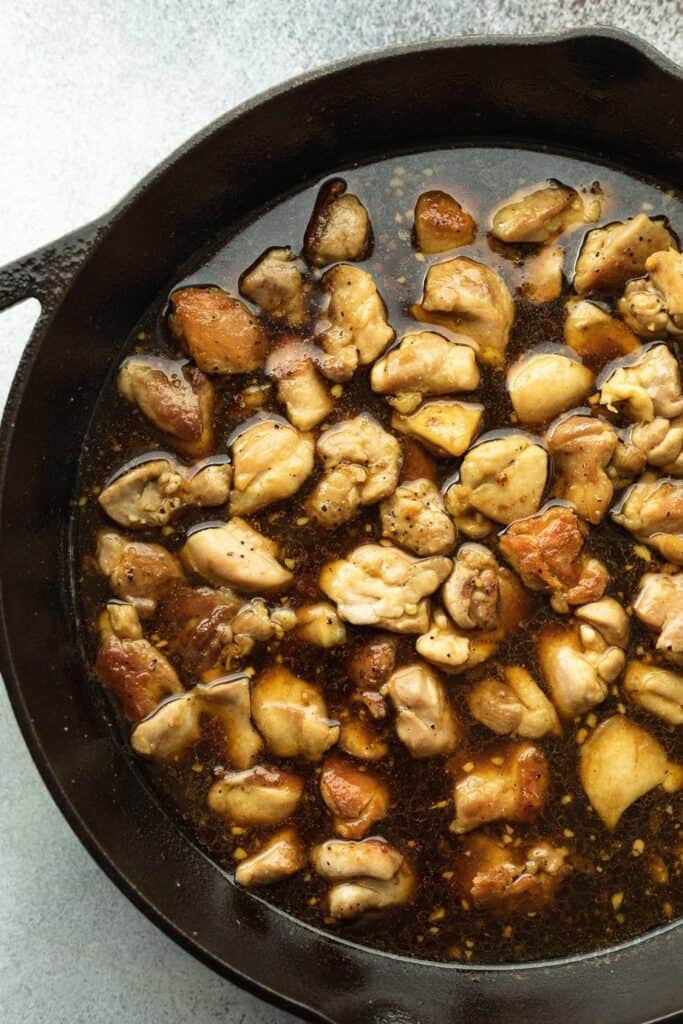 bourbon chicken with sauce in a cast iron skillet