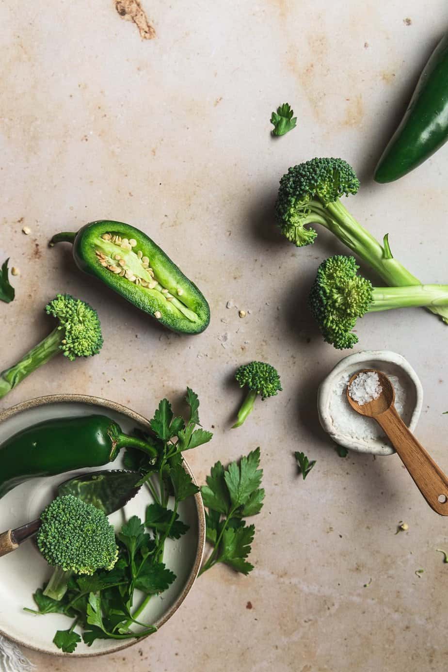 Spicy broccoli soup ingredients on a marble surface. 