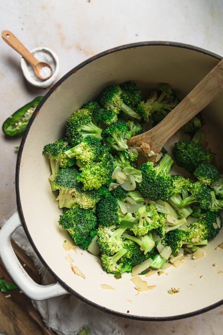 Broccoli in a large soup pot with a wooden spoon. 
