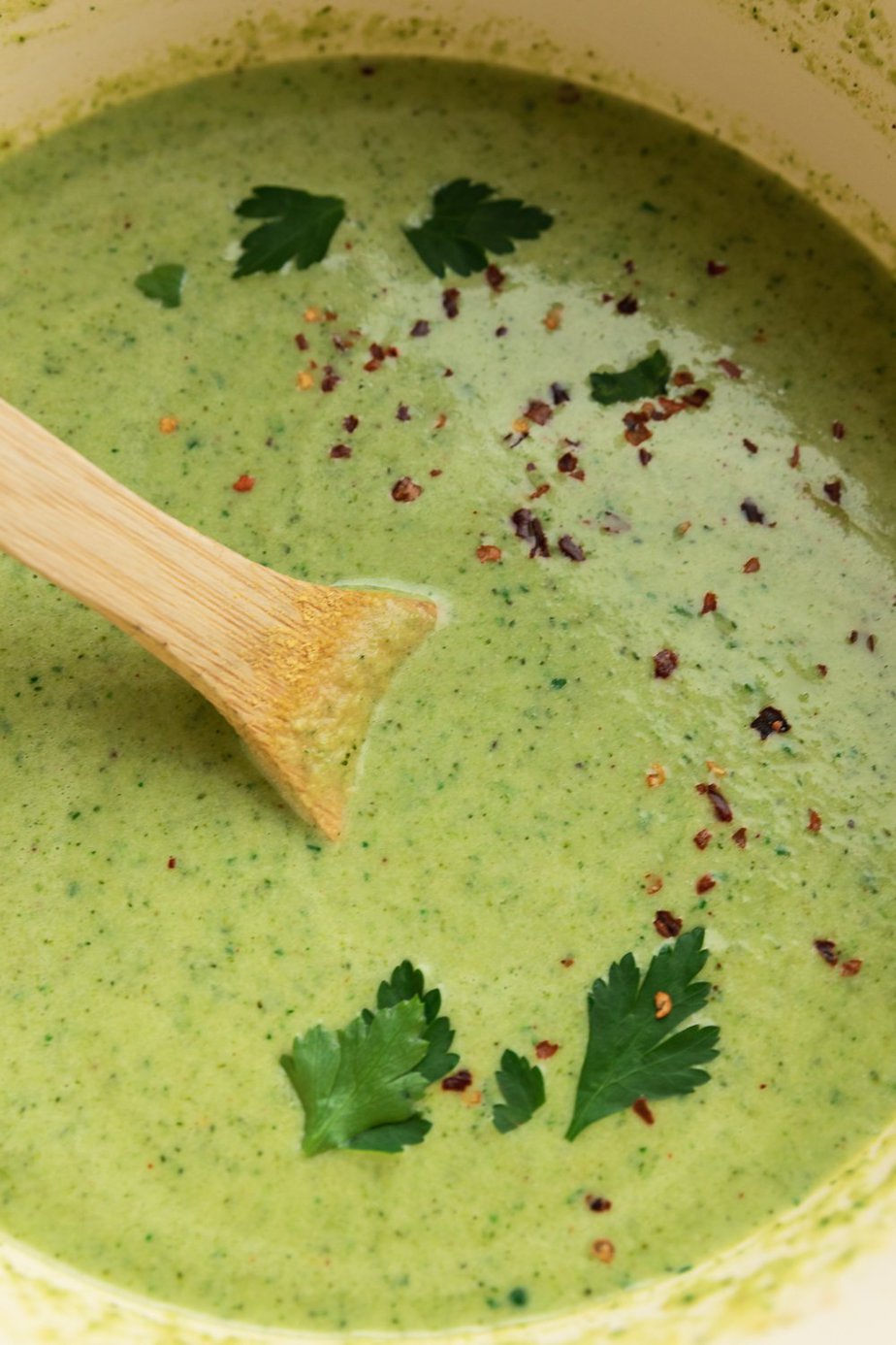 Broccoli jalapeño soup in a large soup pot with parsley. 