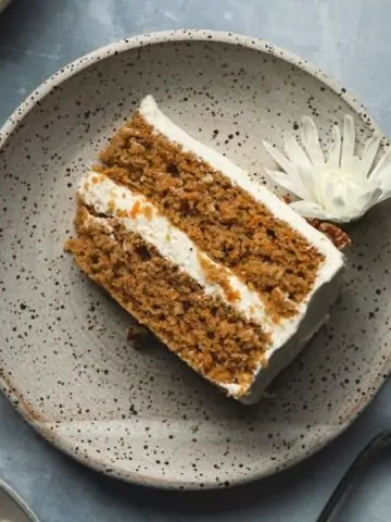 slice of cake on a plate with white flower
