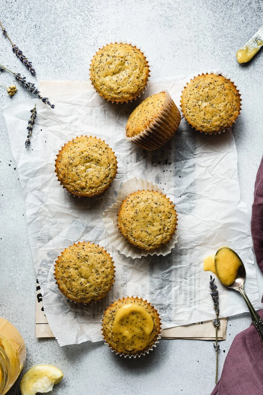 Healthy lemon poppy seed muffins with lemon curd and a purple linen.