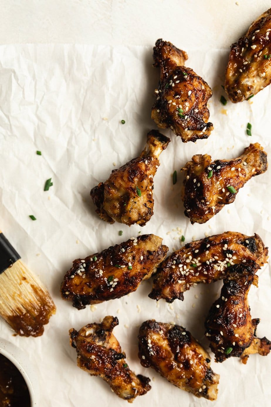 air fryer chicken wings on parchment paper with basting brush