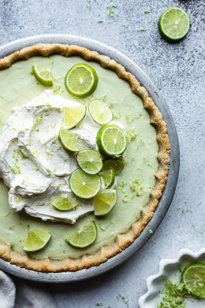 Closeup of the top of a sugar free key lime pie with lime slices.