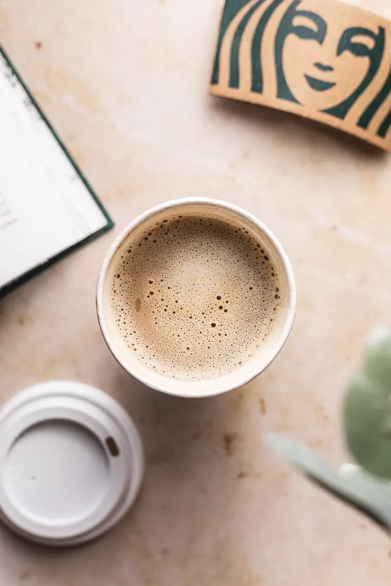 overhead image of a frothy keto Starbucks drink with a book