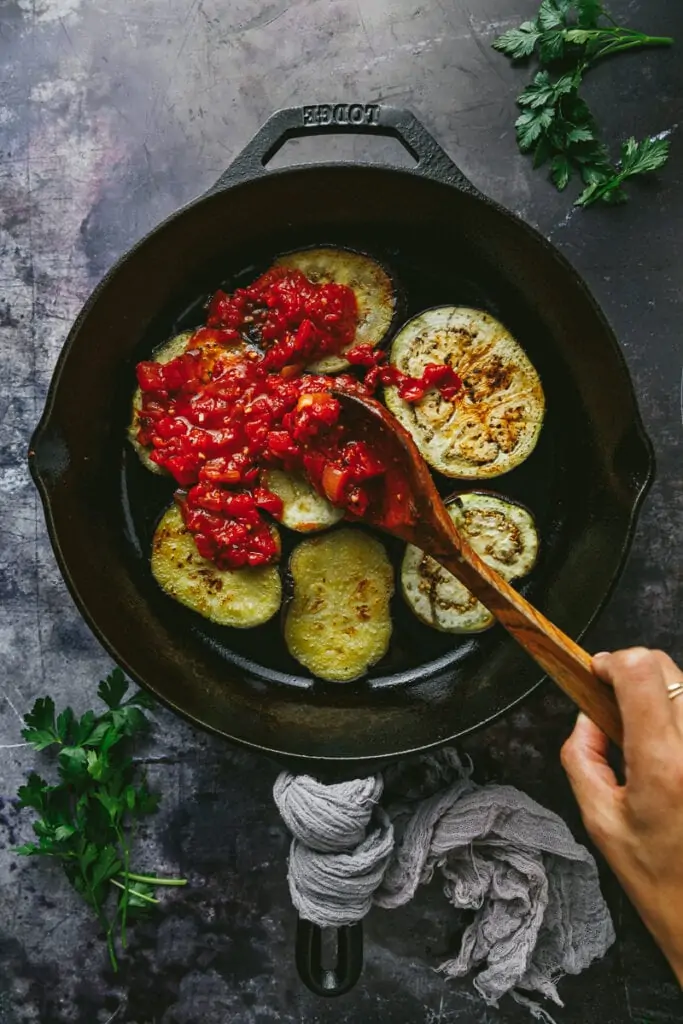 spreading tomato sauce on Turkish eggplant casserole