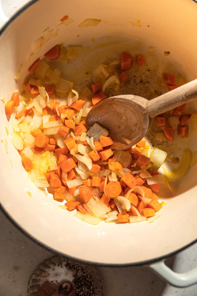 onions, carrots and ginger in a Dutch oven