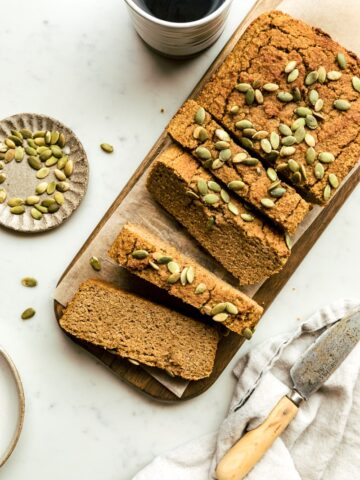a loaf of healthy pumpkin bread with pepitas and coffee