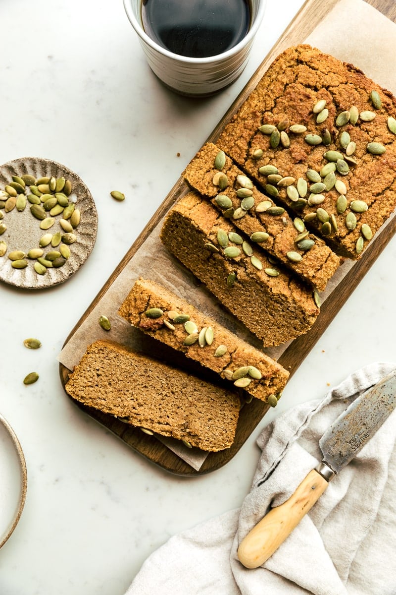a loaf of healthy pumpkin bread with pepitas and coffee