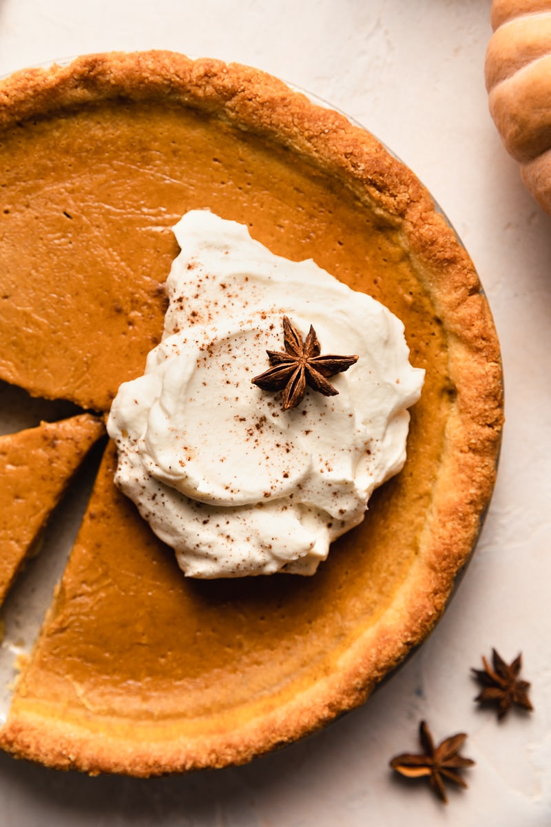 keto pumpkin pie with whipped cream and cinnamon on top