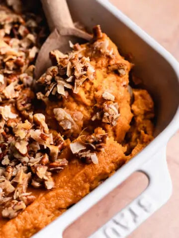 wooden spoon scooping a serving of healthy sweet potato casserole