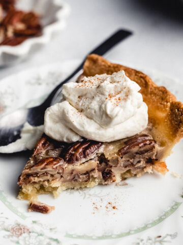 slice of keto pecan pie on a plate with whipped cream