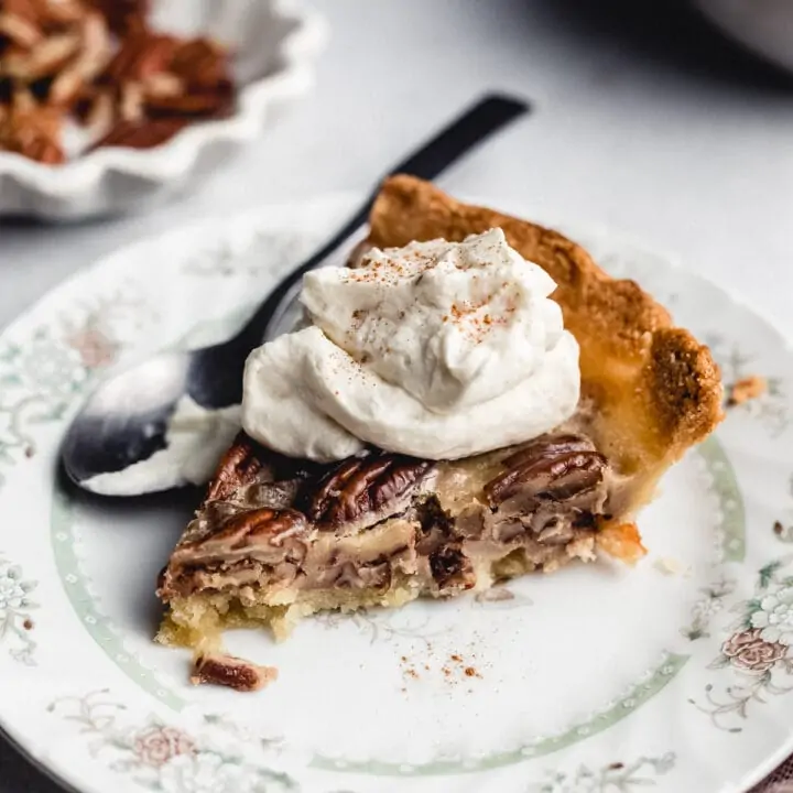 slice of keto pecan pie on a plate with whipped cream