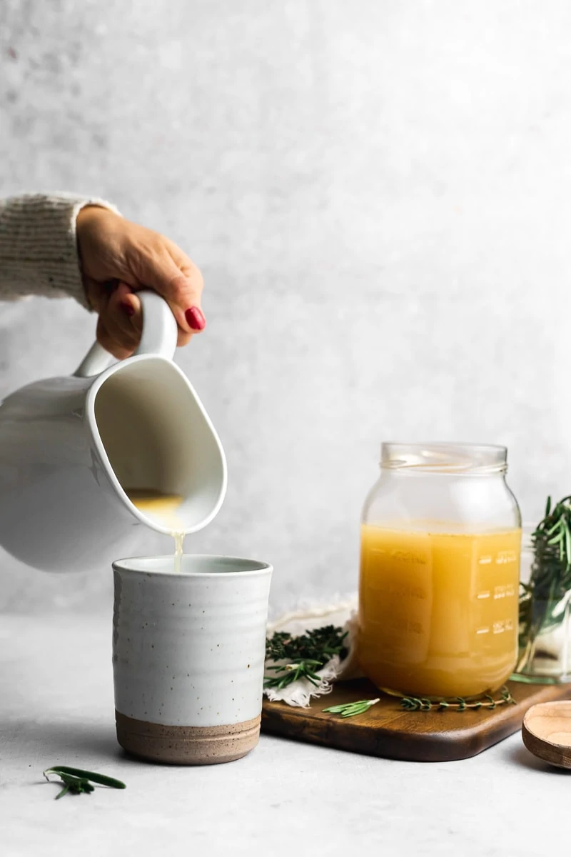 pouring chicken bone broth into a mug