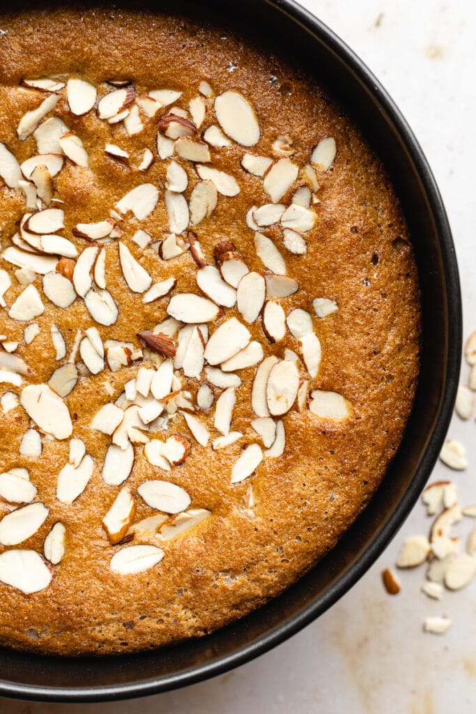 closeup of cake in the pan with almonds baked into the top