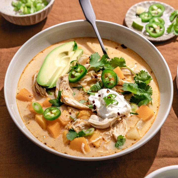keto chicken chili in a bowl with toppings and a silver spoon