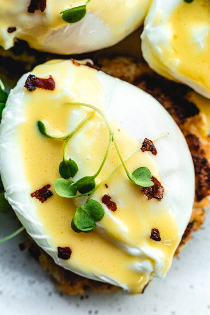 closeup of poached egg with hollandaise and microgreens