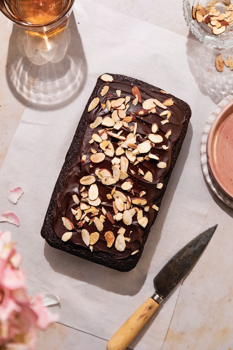 keto chocolate pound cake with almonds on top on a table