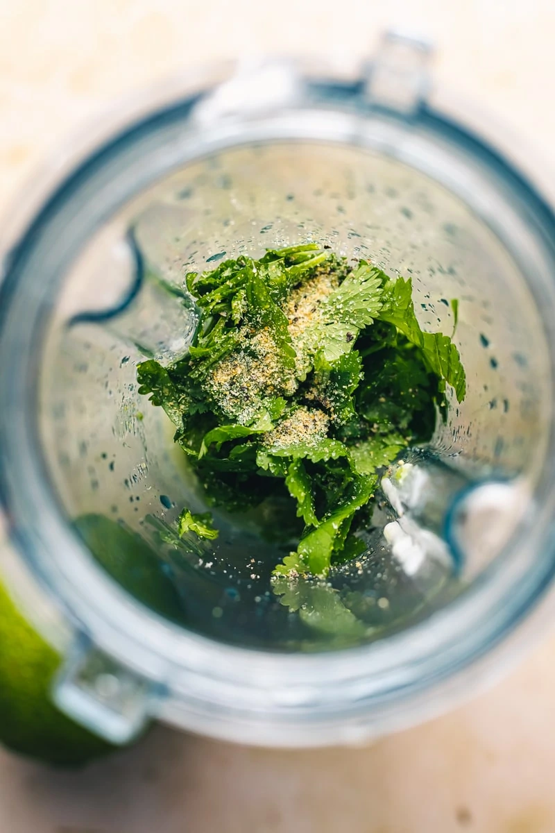 Close up of cilantro crema ingredients in a blender.